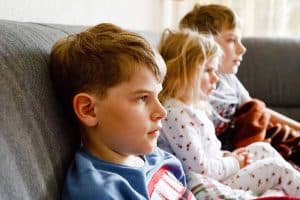 Děti na pohovce se dívají na televizid